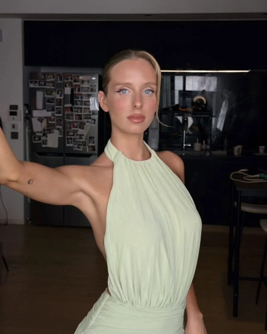 Express tanning client in a pale green halter dress